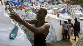 A man sets up a tent in a make-shift camp at a golf course on January 24, 2010 in Port-au-Prince, Haiti. 