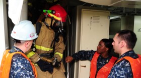 Sailors assigned to the damage control training team instruct a fire team on proper space-entering procedures during a general quarters drill aboard the aircraft carrier USS Ronald Reagan (CVN 76).