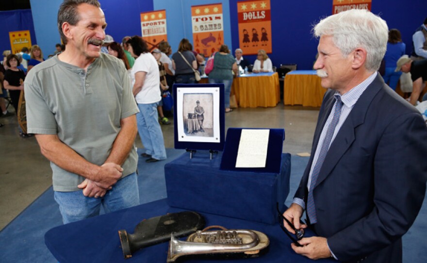 Frederick W. Oster (right) appraises an 1861 E.G. Wright silver cornet with letter for $35,000 in Kansas City, Mo.