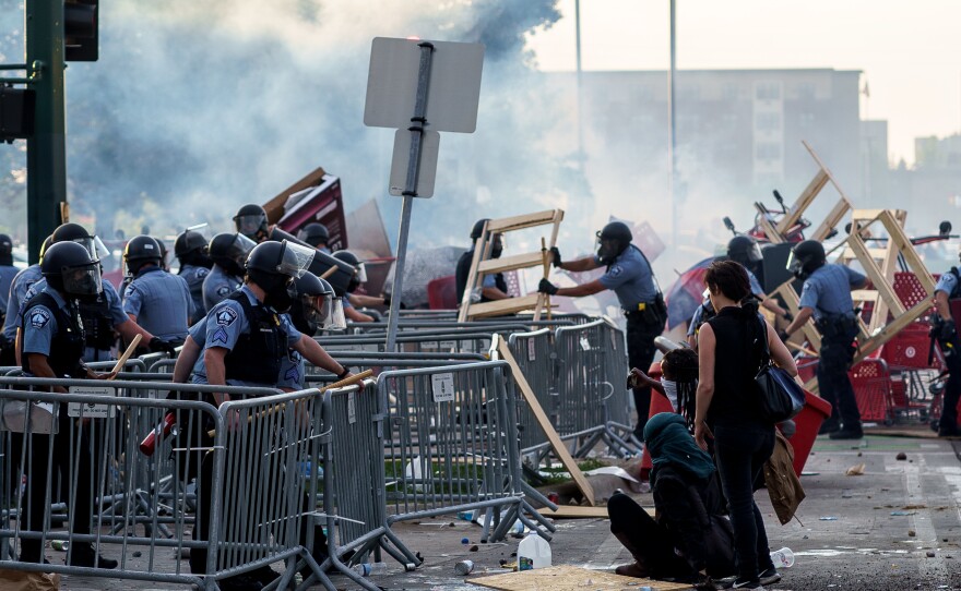 Protesters approach riot police during a demonstration Wednesday evening in Minneapolis. The protests turned violent as unrest erupted once more over the death of Floyd.