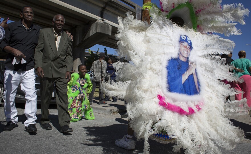Jesse Carter, spyboy with the Mardi Gras Indian tribe, Shining Star Hunters, prepares to march in a jazz funeral in downtown New Orleans on Oct 22, 2016. On the back of his feathered costume is part of the cutout of his sister, Tyronika Carter, who he said was shot and killed in Houston in 2006.