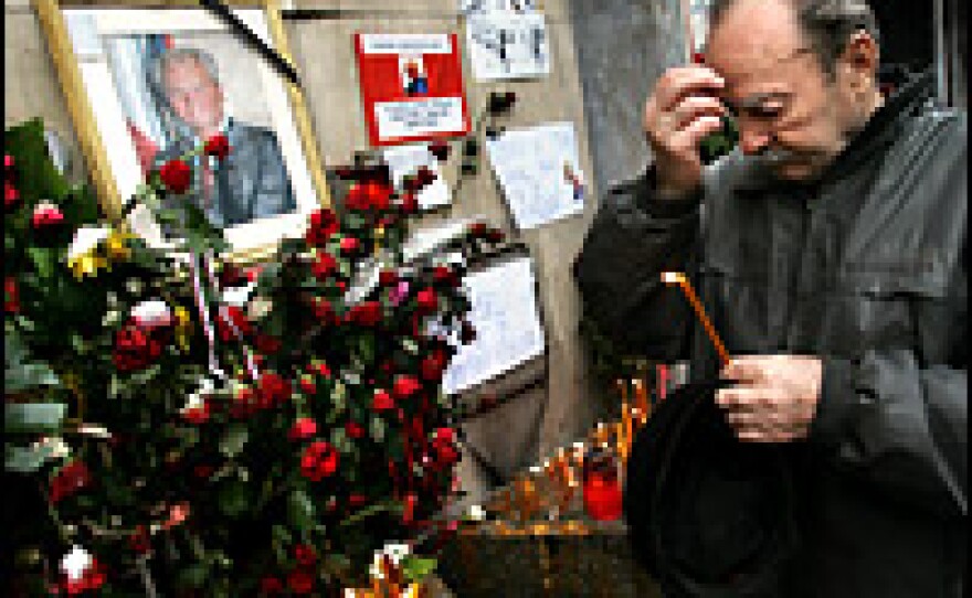 An elderly supporter of former Yugoslav president Slobodan Milosevic makes the sign of the cross on Monday as dozens of hardcore loyalists waited in line in the snow to pay tribute to their late idol in front of his party seat in central Belgrade.