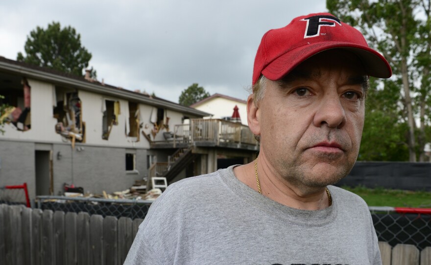 Leo Lech stands on a pile of wood in his neighbor's yard, which overlooks the back of his former home in Greenwood Village, Colo. In 2015, the home was destroyed by the police during a standoff with a gunman and has since been razed and rebuilt. On Tuesday, a federal appeals court ruled that the city does not owe Lech any compensation.