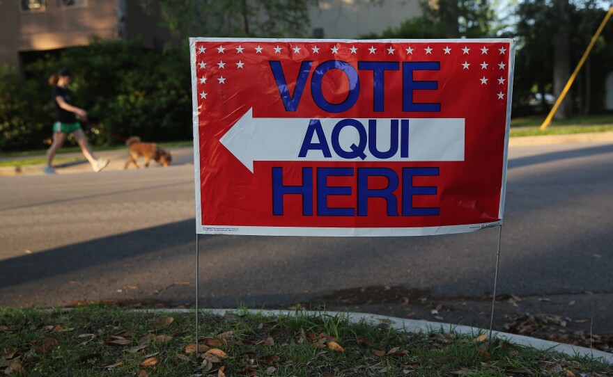 A bilingual sign stands outside a polling center at a public library ahead of local elections on April 28, 2013, in Austin, Texas.