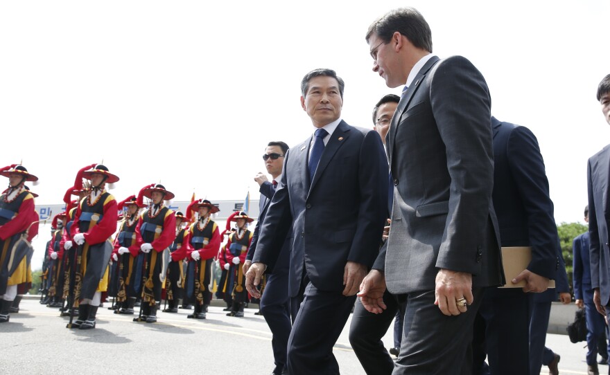 U.S. Defense Secretary Mark Esper (front right), flanked by South Korean Defense Minister Jeong Kyeong-doo (center), arrives at the Defense Ministry in Seoul, South Korea, on Friday.