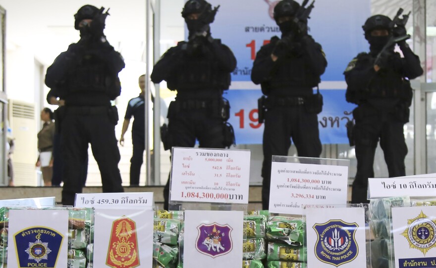 Thai policemen stand in front of packages of methamphetamines on display during a press conference at Narcotics Suppression Bureau in Bangkok, Thailand on July 15, 2019.