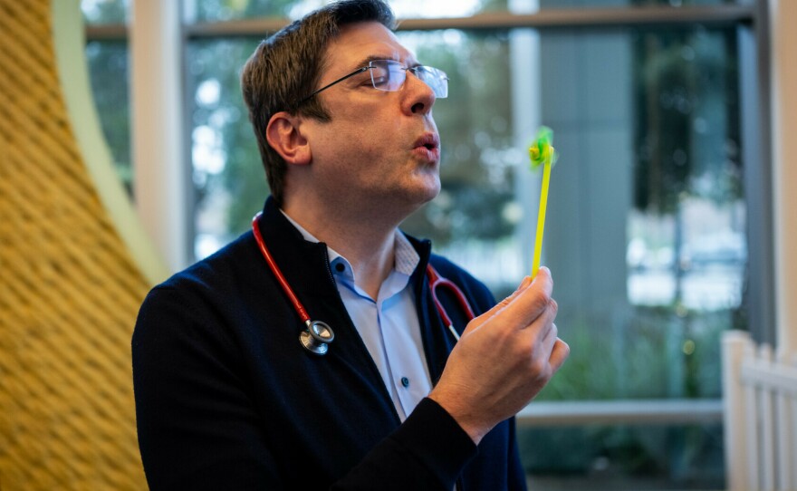 Dr. Stefan Friedrichsdorf demonstrates one of the distraction techniques he uses for children receiving shots at UCSF Benioff Children's Hospital in San Francisco on Dec. 18.