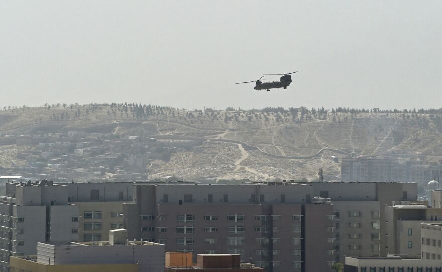 A U.S. military helicopter is pictured flying above the U.S. Embassy in Kabul on Sunday. The Taliban swept into Kabul, facing little resistance.