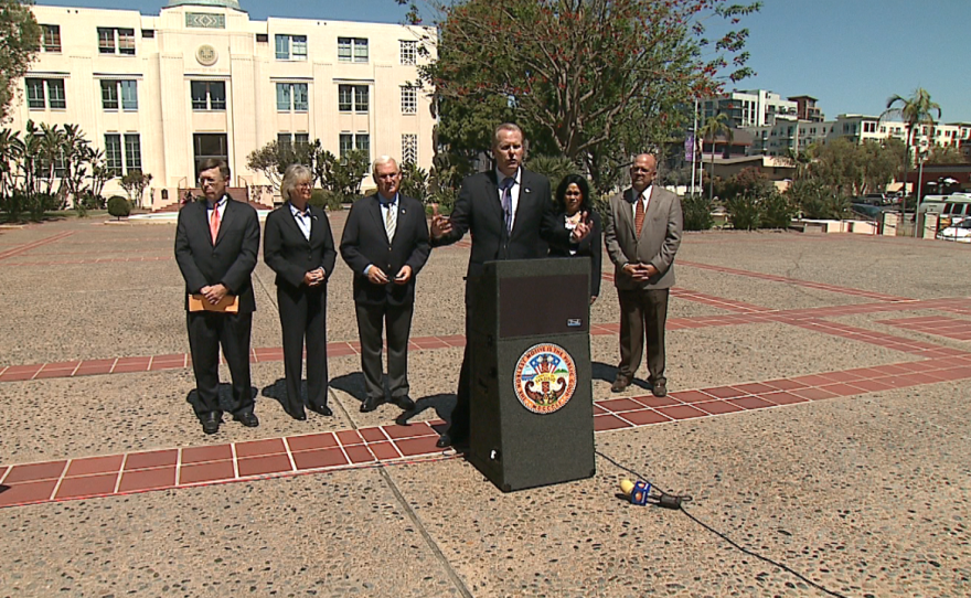 Mayor Kevin Faulconer stands amid local officials and announces a partnership between San Diego County and the city to hire consultants to help develop a funding plan for a new Chargers stadium, March 26, 2015. (From left: San Diego City Attorney Jan Goldsmith, County Supervisor Dianne Jacob, County Supervisor Ron Roberts, City Councilwoman Myrtle Cole and City Councilman Scott Sherman.)