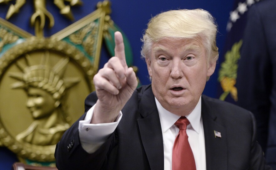 President Donald Trump signs executive orders in the Hall of Heroes at the Department of Defense on Friday in Arlington, Va.