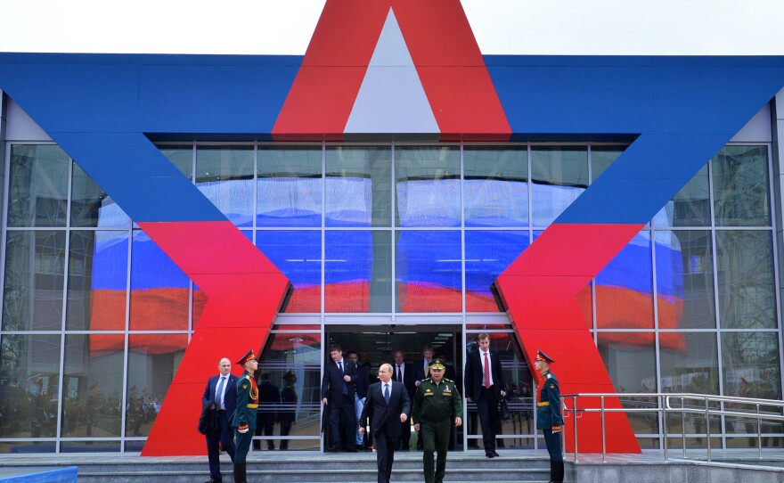 Russian President Vladimir Putin (center left) and Defense Minister Sergei Shoigu (center right) arrive for the opening of the Army-2015 international military show outside Moscow in June.