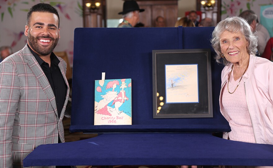 Travis Landry (left) appraises a Dr. Seuss-illustrated program and drawing at Hotel del Coronado in Coronado,
California.