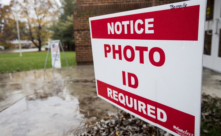 North Carolina will join Virginia and 17 other states that require voters to show a photo ID to vote. A sign notifies voters that a photo ID is required at the Clarke County Schools office polling location in Berryville, Va., on Nov. 6, 2018.