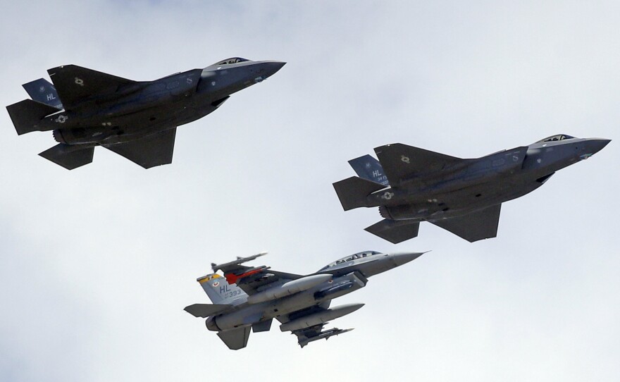 An F-16 escorts two F-35 fighter jets arriving at Hill Air Force Base in Utah. Each stealth F-35 costs about $90 million.