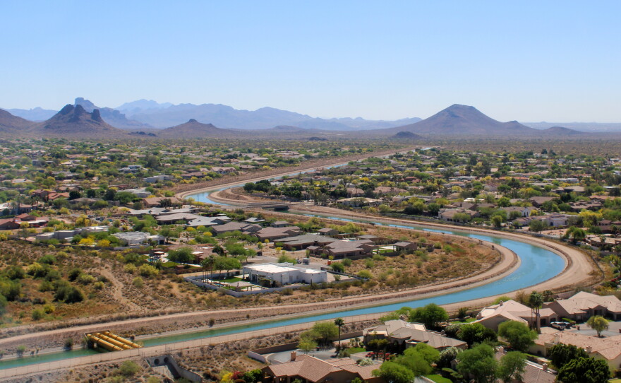 The Central Arizona Project canal winds through a neighborhood in the Phoenix area on March 26, 2026. The massive water-moving system is among the hardest-hit by new federal plans for water cutbacks on the Colorado River.
