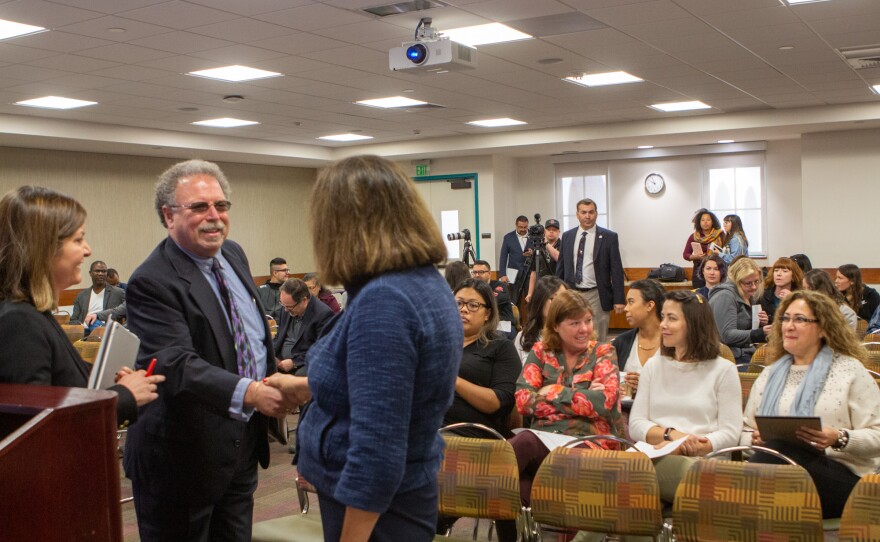 Joel Berman, Vice President of the environmental consulting firm Health Science Associates, shakes hands with San Diego State University President Adela de la Torre at a public forum held during the school's spring break, April 2, 2019.