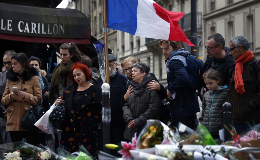 People gather outside Le Carillon, a bistro in Paris's 10th arrondissement that was attacked on Friday.