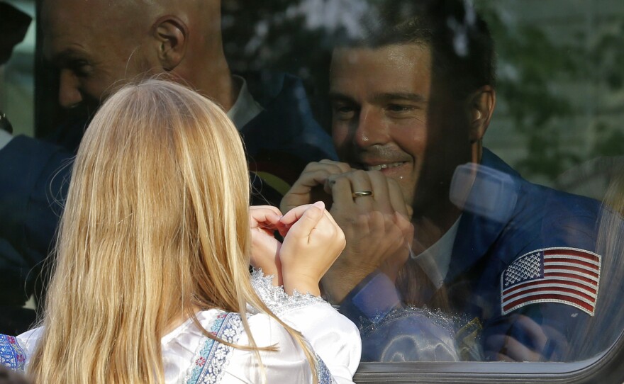 Reid Wiseman exchanges heart gestures with one of his daughters from a bus before his crew's rocket launched from Kazakhstan in May 2014. He went on to spend 165 days at the International Space Station.
