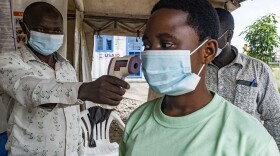 To keep Ebola from spreading in this current outbreak, a border health officer at the Busunga crossing between Uganda and the Democratic Republic of Congo checks a traveler's temperature using a contactless infrared thermometer on May 18.