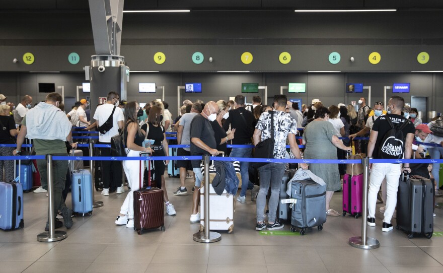 Passengers queue up at Greece's Thessaloniki Makedonia Airport on Sept. 2. Recommendations about physical distancing prove hard to follow at airports — and in the jetway leading to the plane.