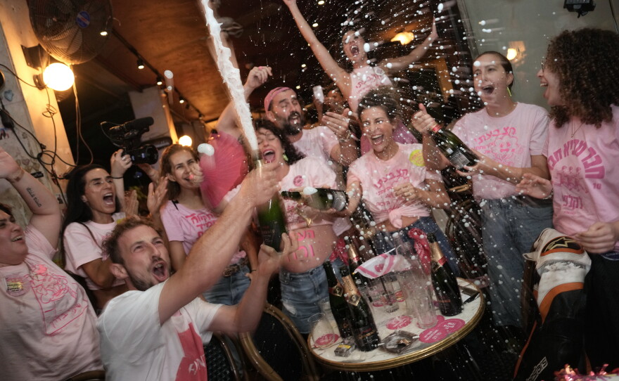 People spray sparkling wine as they celebrate early exit poll results for Israel's general election in Tel Aviv, Israel, Tuesday, Oct. 27, 2026.