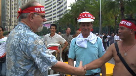 Roy Koch shakes the hand of ironworkers during one of the largest strikes in Hong Kong in the past century.