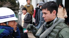 OSHIMA, Japan (March 21, 2011) Lt. j.g. Jaden Risner, assigned to the Black Knights of Helicopter Anti-Submarine Squadron embarked aboard the aircraft carrier USS Ronald Reagan, speaks with a Japanese citizen during a humanitarian assistance mission. Ronald Reagan is operating off the coast of Japan providing humanitarian assistance as directed in support of Operation Tomodachi. 