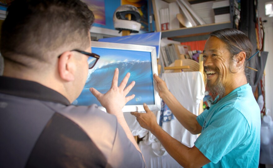 Artist Anh Pham (right) shows one of his wave paintings made with depth of field effect.