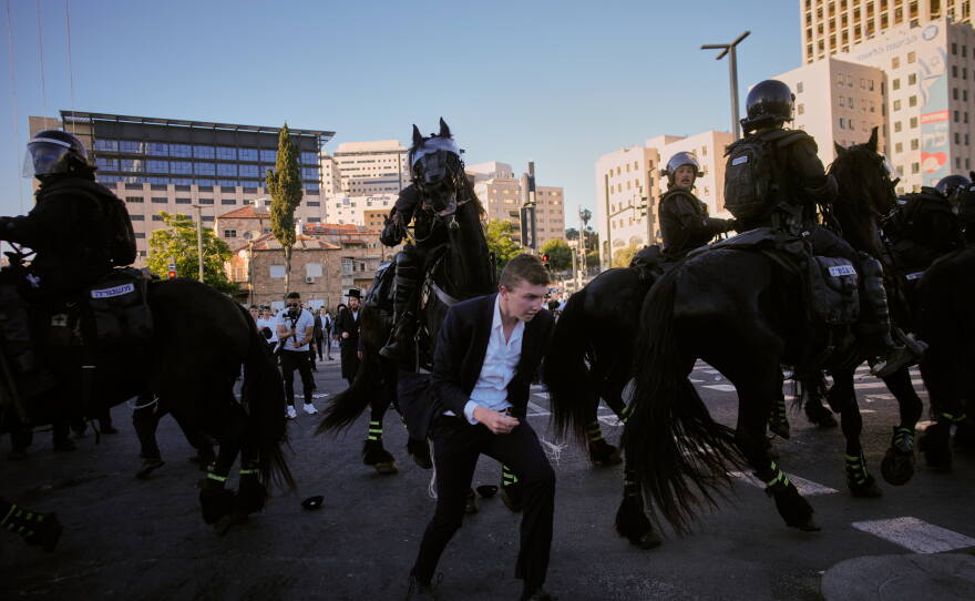 Israeli mounted police disperse Ultra-Orthodox Jews blocking a road during a protest against army draft in Jerusalem, Monday, June 1, 2026.