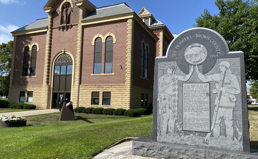 On the New Ulm courthouse lawn, a marker congratulates settlers' founding of the territory of Minnesota. The symbol on the Native person's clothing was an ancient cultural sign for many Dakota tribes.