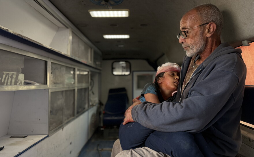 Saqer Al-Ankah holds his dying 10-year-old granddaughter, Bayan, in his arms at Baptist Hospital in Gaza City on Dec. 10, 2025, after she was shot in her tent by Israeli troops who occupy northeast Gaza.