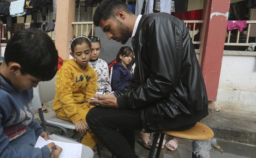 English teacher Tariq Al-Annabi holds a class in a United Nations-run school in Rafah, Gaza Strip, on Sunday — the third day of a temporary cease-fire between Hamas and Israel.