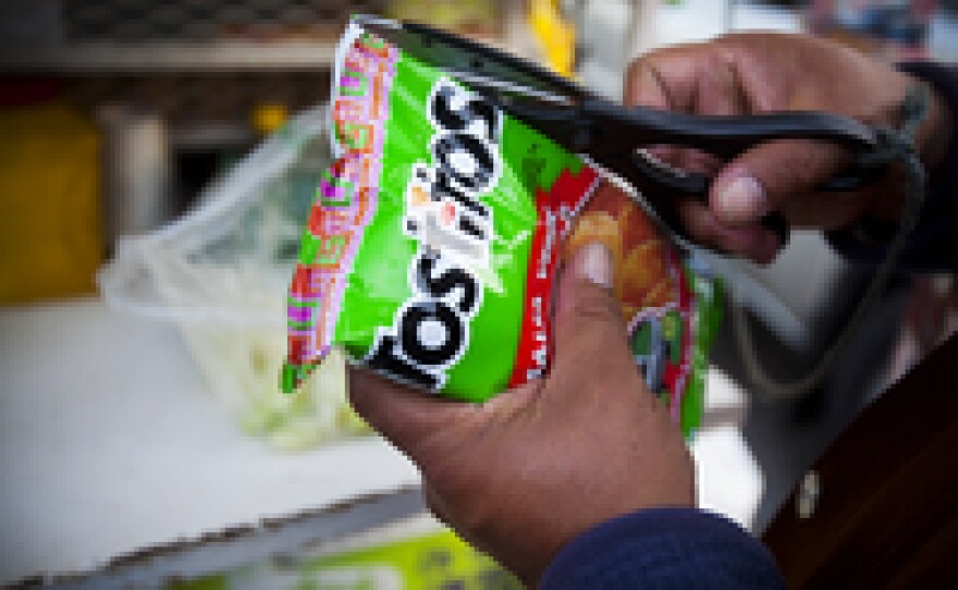 First, cut the bag of Salsa Verde Tostitos lengthwise.