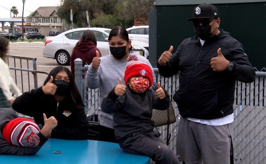 Giovanni Meza and his family give thumbs up for their negative COVID-19 tests taken Monday at the San Diego Unified School District headquarters test center in University Heights, December 27, 2021