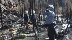 Colorado State University hydrologist Stephanie Kampf (right) and a team of research assistants assess the Cameron Peak burn scar to place a weather station. 