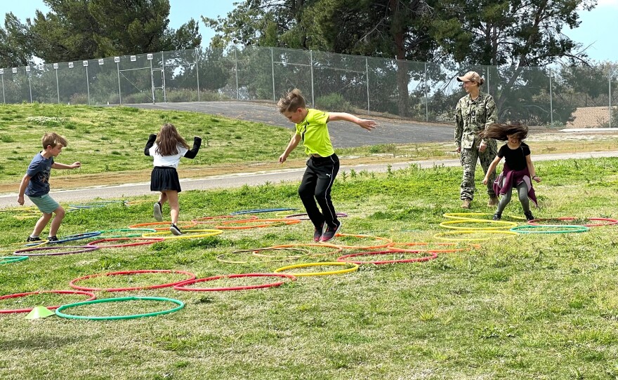 Lt. j.g. Emily Stoops Jaynes (uniform) is a crew member aboard the USS Pearl Harbor. She led students in activities during a field day boot camp, Friday, at Hancock Elementary, San Diego, Calif., April 14, 2023.