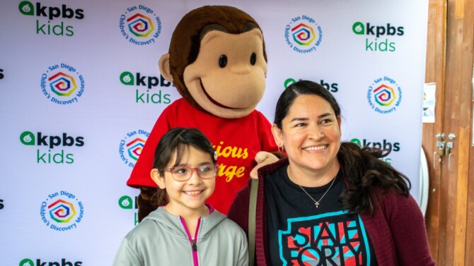 KPBS Kids event where daughter and mother are in front of Curious George
