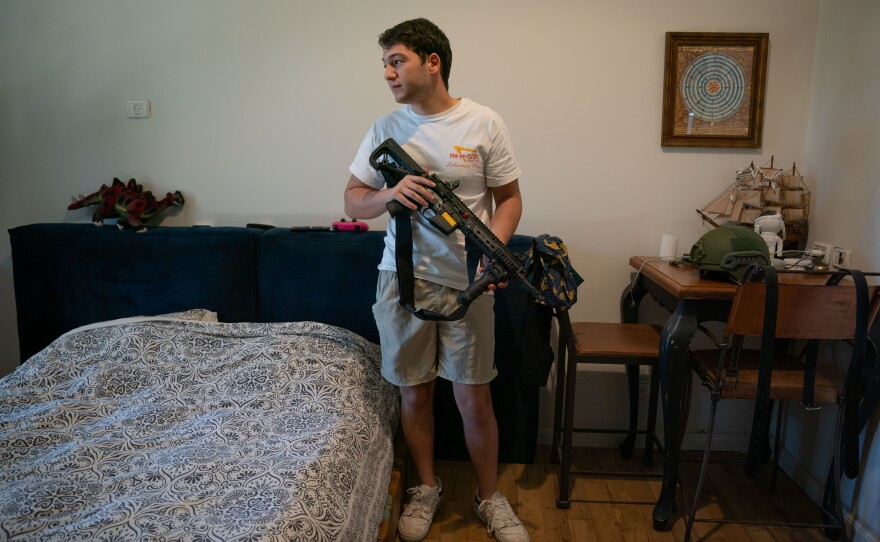 Ori Kahan, 21, in his bedroom in the central Israeli community of Rishpon. Kahan volunteers in his community's security squad. The group existed before the war, but since Oct. 7, it has received arms, protective gear and training from the police, and has been on a higher state of alert.