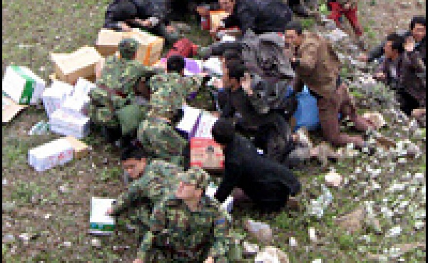 Survivors gather to wait for a Chinese military helicopter bringing supplies to Wenchuan, the epicenter of the earthquake.
