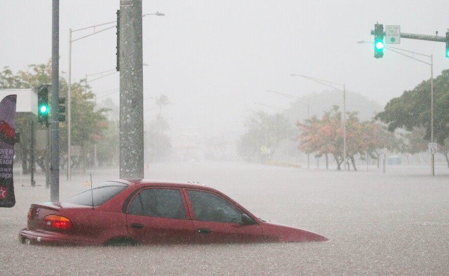 A car is stuck partially submerged in floodwaters from Hurricane Lane rainfall on the Big Island on Wednesday in Hilo, Hawaii.