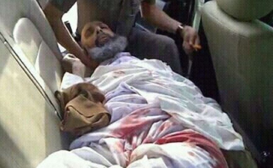 Sheikh Nimr al-Nimr lies wounded in the back of a police car following his arrest in July 2012. A Saudi court sentenced him to death this week for disloyalty to the ruling family and other charges.