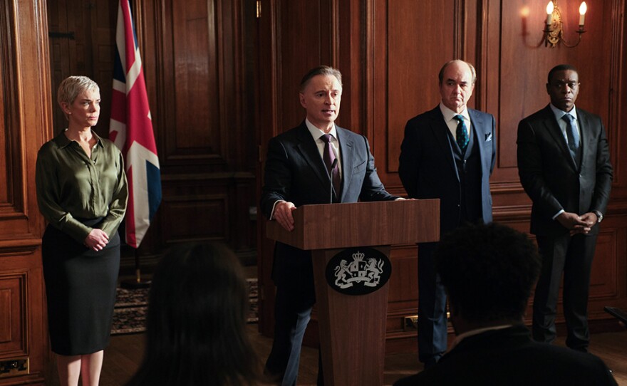 Prime Minister Sutherland (Robert Carlyle) gives an update on the cyber-attack as Anna (Victoria Hamilton), Archie (David Haig), and Joseph (Richard Pepple) look on.