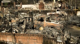 Rubble and burned vehicles line properties scorched by a wildfire in Ventura, Calif. on Wednesday, Dec. 6, 2017.