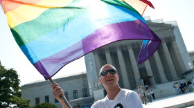 A gay rights activist waves a rainbow flag in front of the U.S. Supreme Court in June, a day before the ruling on the Defense of Marriage Act.