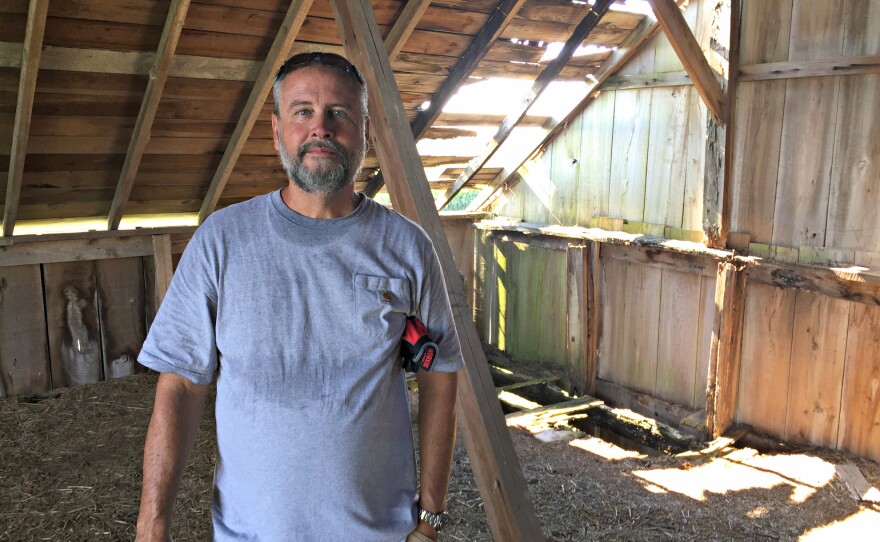 Mike Hudson, standing in the hayloft of his current barn project, says he will deconstruct about 10 to 12 barns in the next year. He sells the reclaimed wood at his lumberyard in Elbert, Colo.