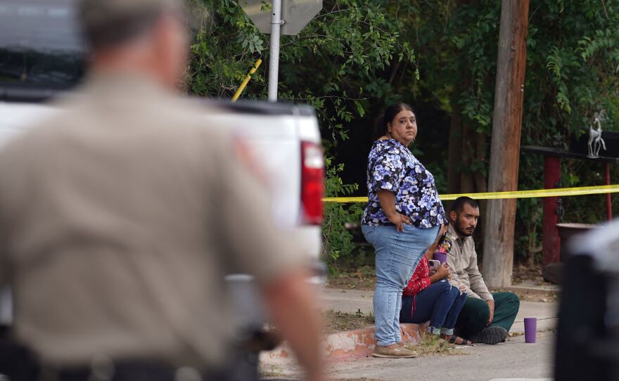 People sit on the curb outside of Robb Elementary School in Uvalde, Texas, on May 24, 2022.