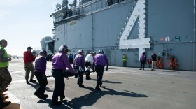 SAN DIEGO (March 8, 2023) – A group of sailors in purple flight deck shirts and float coats carry a person on a stretcher across the flight deck of the amphibious assault ship Boxer. Sailors assigned to USS Boxer respond to a mass casualty drill on the flight deck in San Diego on March 8, 2023. Unable to get to sea, the Boxer's crew has simulated being underway to maintain their training qualifications.