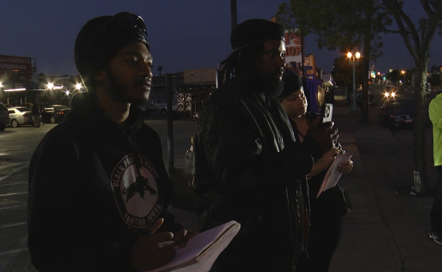 Three members of the local Black Panther Party observe a police stop as volunteers with the Southeast San Diego Accountability Unit on Thursday, April 27, 2023. They divide roles as recorders, notetakers and speakers, making sure to note officers' badge numbers. Koran Fields (center) says the simple act of observing changes police behavior.