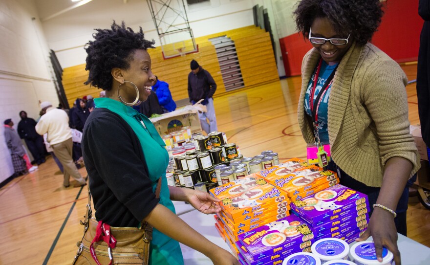 Outreach coordinator Shayna Terrell prepares for the weekly free food pantry in the gym of Simon Gratz Mastery Charter School.