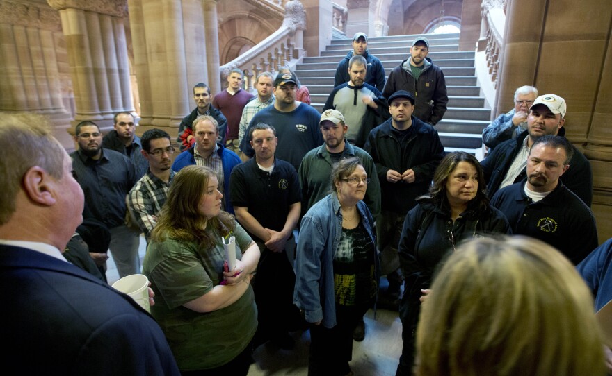 Workers from Remington Arms Company in Ilion, N.Y., talk with Assemblyman Marc Butler (left) and Assemblywoman Claudia Tenney (right) about gun legislation at the Capitol on Jan. 14 in Albany.